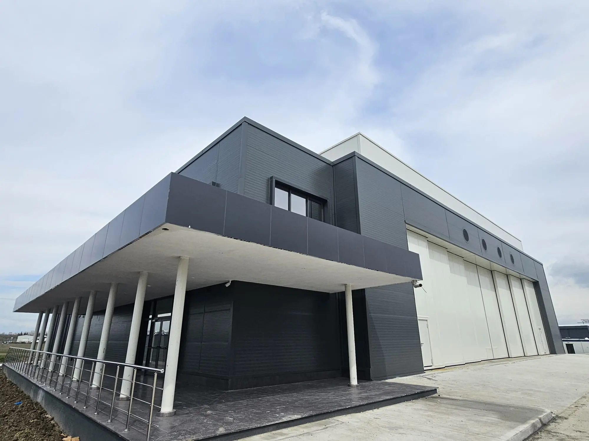 Antrasit kompozit panel saçak ve cephe kaplaması uygulanmış endüstriyel yapı