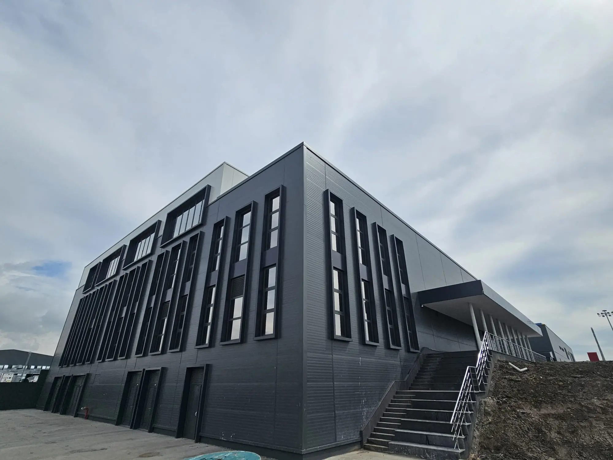Antrasit sandviç panel cepheyle tamamlanmış modern endüstriyel yapı