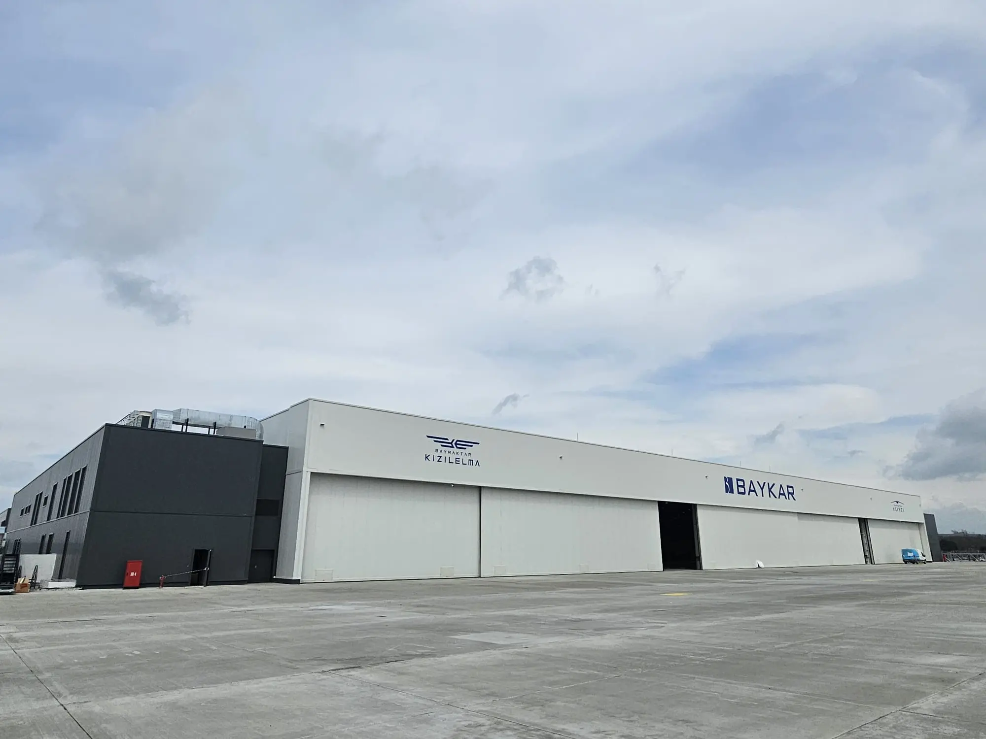 Beyaz ve antrasit panel kaplamalı endüstriyel tesis cephesi